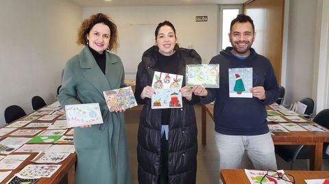 Los miembros del jurado del concurso de postales navideas de Rois Isabel Seage (tcnica de normalizacin lingstica), Vanessa Chico (presidenta del Anpa Urcael) y F. Martn Nez lvarez (profesor del colegio CPI Os Dices) muestran los trabajos ganadores de este ao.