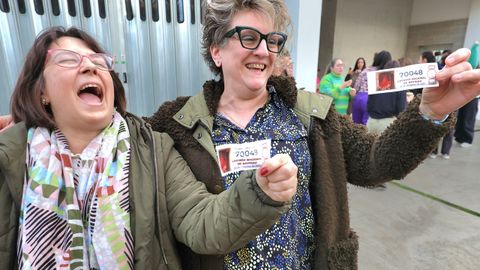 Dos de las trabajadoras con recortes del segundo premio que les ha tocado, el 70048. el primero de la jornada en salir