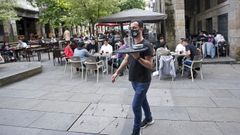 Un camarero sirviendo en las terrazas instaladas en la Praza da Verdura