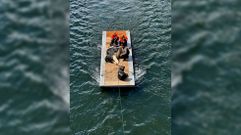 Momento en que una de las vacas es rescatada con un trozo de pantal�n controlado con una cuerta desde la orilla