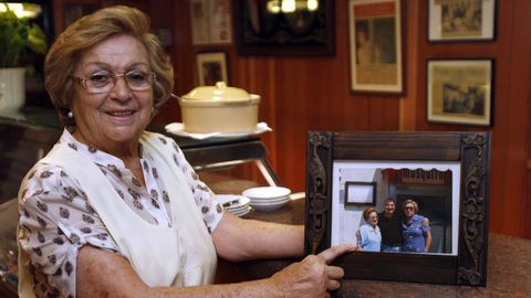 Carmiña Valverde, entonces dueña del restaurante «El Mosquito» sujeta un cuadro en el que aparece María Rodríguez (izquierda), primera estrella Michelin gallega