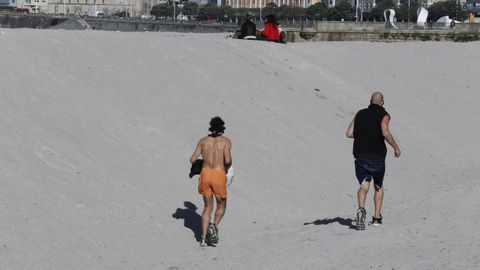 Deportistas corriendo por la playa de Riazor