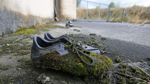 Botas de ftbol olvidadas en el recinto exterior del campo de ftbol de As Lamas