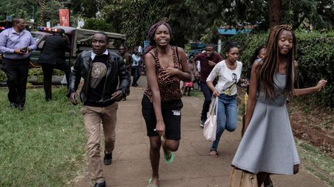 Un grupo de personas buscan refugio en la zona donde se produjo la explosi�n y los disparos, en un hotel de Nairobi, en Kenia