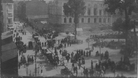 Carros de caballos y ovetenses transitan la ciudad, en una imagen antigua de Oviedo