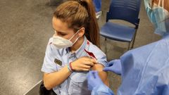 Una agente de los Mossos d'Esquadra recibe la vacuna contra el coronavirus en la primera jornada de vacunaci�n a cuerpos de emergencias