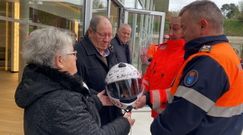 Dos miembros de Protecci�n Civil de Betanzos entregan el casco de Janel a la familia con la firma de todos los compa�eros