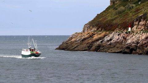 Un barco pesquero entra en el puerto de Avils.