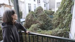 Raquel Abeledo contempla desde su casa la maleza del patio vecino, que trepa por los muros.