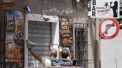 Agentes de polic�a precintan el local donde un hombre de 62 a�os ha matado a un joven de 20 a�os en Valencia.
