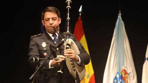 El polic�a David Fern�ndez toca la gaita al inicio del D�a de la Polic�a Nacional