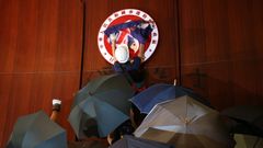 Un manifestante coloca una bandera brit�nica sobre el emblema de Hong Kong tras irrumpir en la sede del Parlamento
