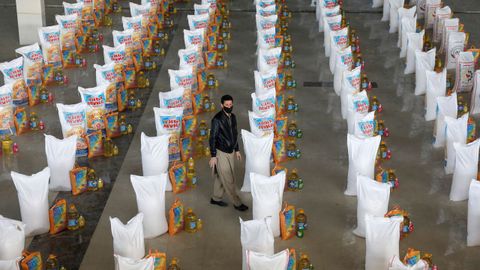 Un afgano, entre los sacos de comida preparados para donar a los ms necesitados