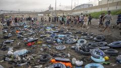 Flotadores y migrantes tras traspasar la frontera entre Ceuta y Marruecos