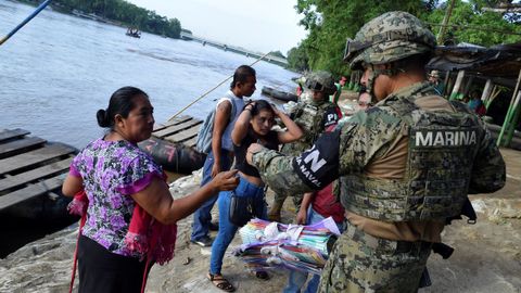 Un miembro de la polic�a naval procede a la identificaci�n de una mujer guatemalteca que cruz� el r�o Suchiate en una balsa desde Tecun Uman, en Guatemala, hasta Ciudad Hidalgo