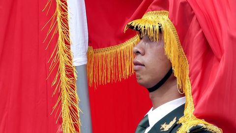 Un miembro de la guardia de honor china, cubierto por una bandera, durante la recepci�n en Pek�n a Vladimir Putin