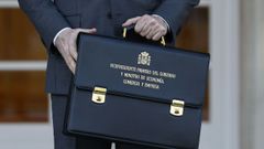 El nuevo vicepresidente primero del Gobierno y ministro de Econom�a, Comercio y Empresa, Carlos Cuerpo, posa con su cartera a la entrada del palacio de la Moncloa a su llegada este martes a la reuni�n del Consejo de Ministros.