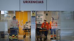 Sanitarios y pacientes en la entrada de urgencias del Chuac.