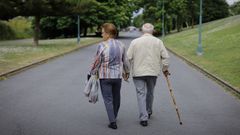Un matrimonio de personas mayores paseando por A Corua