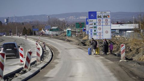 Una familia camina por la carretera despus de cruzar la frontera entre Ucrania y Polonia