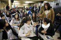 La conselleira, de pie, saludando a los estudiantes a su entrada al sal�n de actos del instituto. 