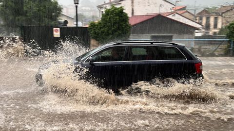 Un coche circula por una calle de Oviedo que se encuentra inundada tras las �ltimas lluvias registradas en la regi�n.