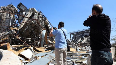 Dos iran�es ante un complejo deportivo destruido en las �ltimas horas en Teher�n