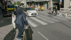 Un hombre con bastn, tratando de cruzar el paso de peatones entre las obras.