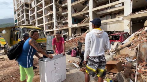 Fredy Silva y Yumely Aguilera con una nevera que acaban de recoger en su apartamento, ubicado en un edificio en ruinas.