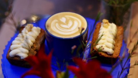 Un caf� con un tipul�n de leche y dos dulces