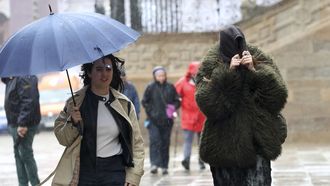 Peatones protegi�ndose de la lluvia en la plaza del Obradoiro de Santiago. 