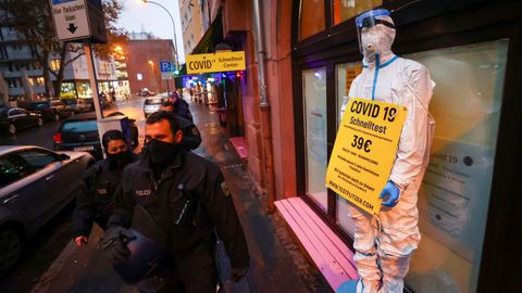 Policas alemanes pasan por delante de un bar reconvertido en tienda de artculos de proteccin contra el covid en Frankfurt