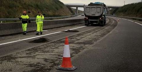 Dos trabajadores en las obras de mejora del firme que la Xunta ha iniciado en la AG-55 y que han obligado a cortar un carril. 