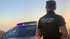 Un agente de la Polica Canaria y un coche patrulla.