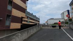 Una mujer accede a la plaza (debajo est� el s�tano donde ardieron los coches) y al edificio de arriba, habitado, a diferencia del de la parte inferior, inacabado y desvencijado