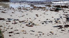Zapatillas y neum�ticos en una playa de Cai�n