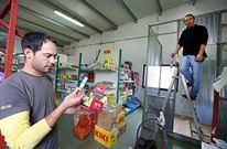 El trabajador de un negocio de Ribeira muestra productos que se venden sin permiso y que son menos agresivos; al fondo, su compa�ero, haciendo una estructura para guardar los restringidos. 