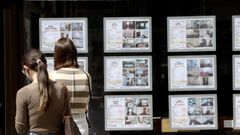 J�venes consultan la fachada de una inmobiliaria en Santiago.