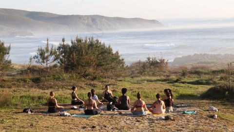 En la imagen, una sesión de yoga de Ashtanga Coruña en la costa de Ferrol