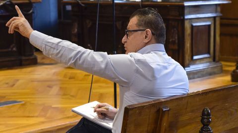 El acusado, Nikolin, en la Audiencia de Pontevedra, tomando apuntes y pidiendo hablar con su letrada durante el juicio.