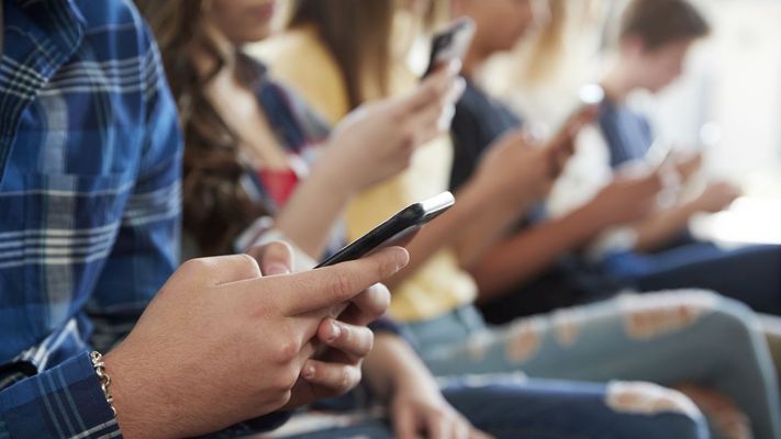 Menores usando sus tel&eacute;fonos m&oacute;viles