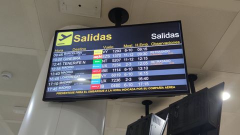Pantallas en el aeropuerto de Alvedro anunciando los retrasos en las salidas
