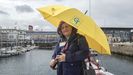 Mónica Díaz, con el paraguas amarillo que identifica a los guías turísticos oficiales de Galicia, en la dársena de la Marina, en A Coruña  