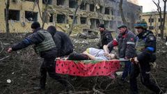 Un grupo de personas trasladan a una herida tras el bombardeo de un hospital en Mari�pol