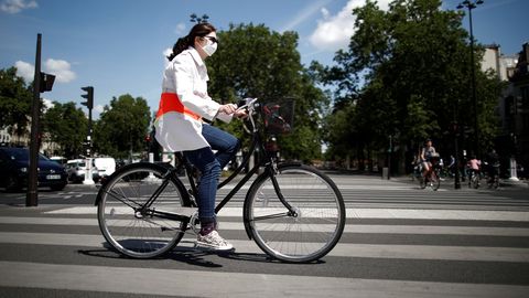 Una mujer en bicicleta y con mascarilla por Pars