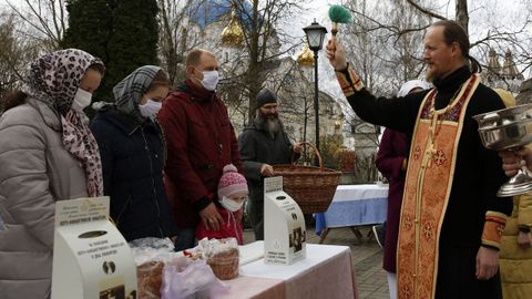 Un sacerdote ortodoxo bendice a los hermanos y sus canastas llenas de comida en la vspera de la Pascua en un convento en las afueras de Minsk, Bielorrusia.