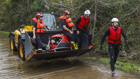Un granjero transporta a un grupo de bomberos, que trabajan en la zona de Co�mbra afectada por la rotura de un dique