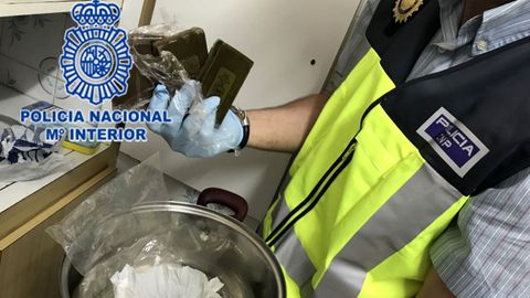 Un agente muestra algunas de las porciones de hach�s halladas en el registro del domicilio del traficante de El Cerillero