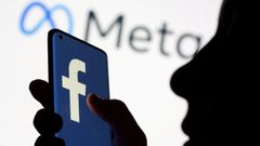 Una persona sostiene un mvil con el logotipo de Facebook, propiedad de Meta.