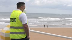Un empleado de la empresa de Sereno de Gij�n controla el acceso a la playa de San Lorenzo, este lunes en Gij�n